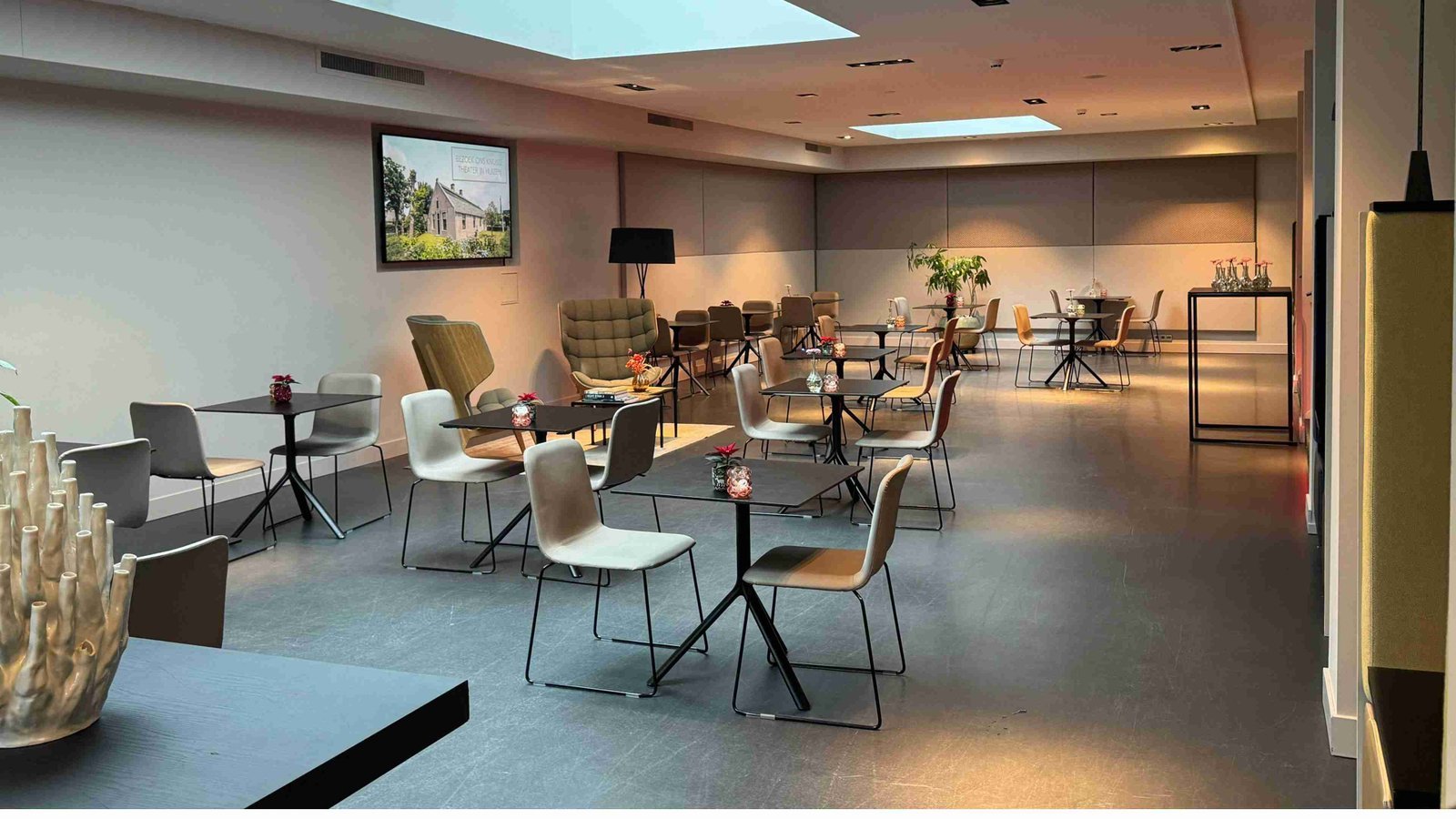Narrowcastingscherm in een sfeervolle zakelijke lounge